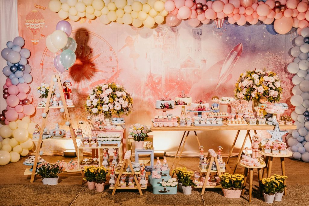 Una atractiva barra de dulces con globos y decoración floral para una celebración festiva en el interior.